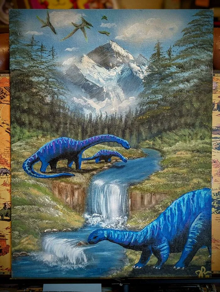 Personalized thrifted painting showing blue dinosaurs by a waterfall with mountains and birds in the background.
