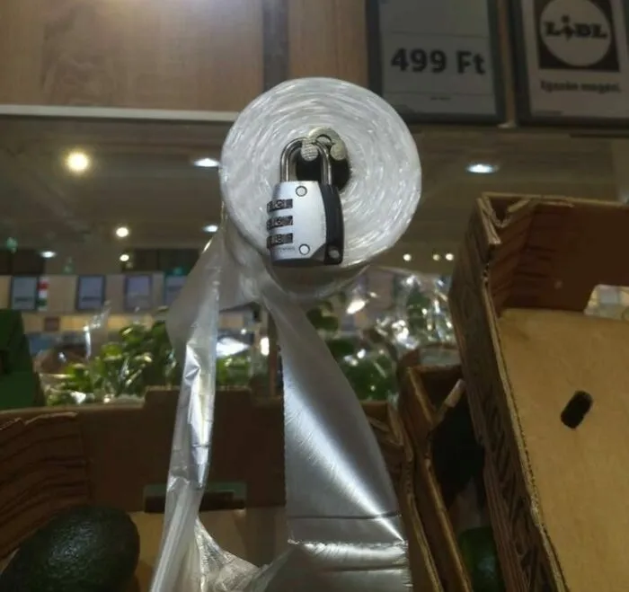 Roll of plastic wrap locked with a combination padlock in a store, illustrating Eastern Europe humor and memes.