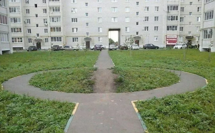 Overgrown sidewalks and paths in a residential area typical of Eastern Europe humorously showing urban design quirks.