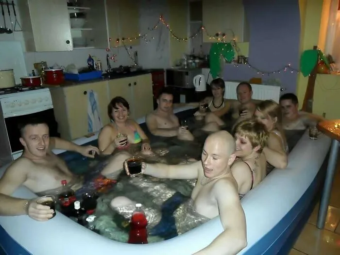 Group of friends in an indoor inflatable hot tub drinking and relaxing, typical Eastern Europe humor and lifestyle moment.