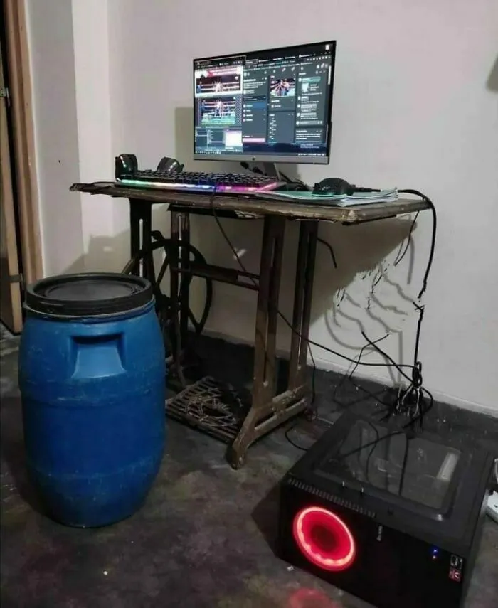 Old sewing machine table converted into a PC setup with a barrel chair, illustrating Eastern Europe humor and memes.