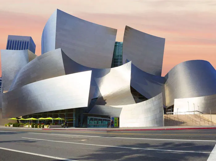 Abstract modern building with curved metallic panels under a sunset sky, showcasing unique bread-shaped bread factory architecture.