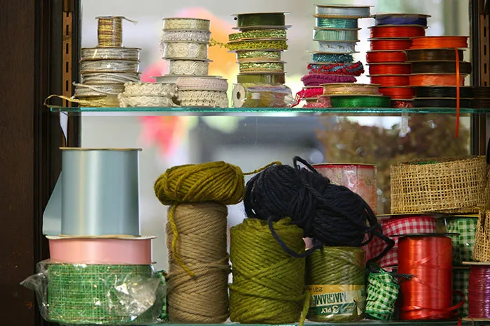 Various colorful ribbons and yarns arranged on glass shelves, representing worst gifts people have ever received.