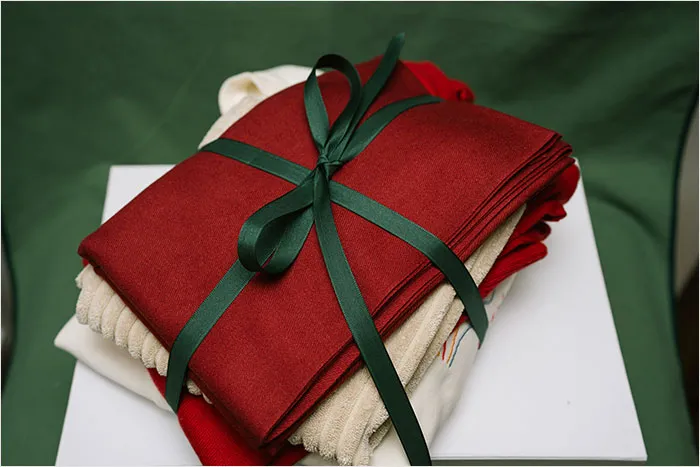Stack of folded fabric tied with green ribbon, representing some of the worst gifts people have ever received.