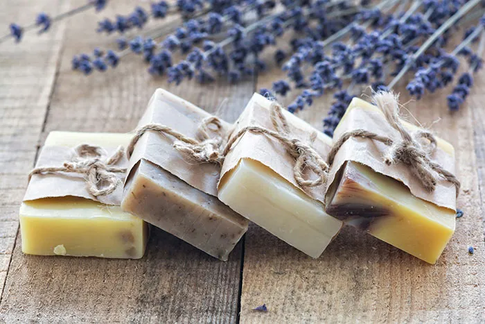 Four bars of handmade soap tied with twine on a wooden surface, representing worst gifts received by people.
