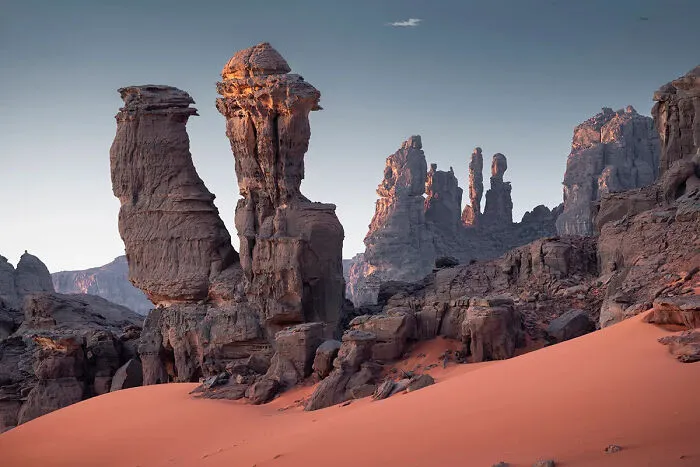 Top 101 Photographs Of The Year: A Series Of Dark Sculptures Rises From The Reddish Sands Of The Central Sahara Desert, Tassili N'ajjer National Park, Algeria, By Henrique Murta