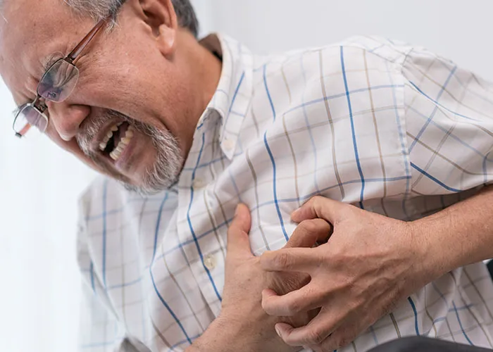 Elderly man clutching chest in pain, depicting one of the absolutely chaotic scenes witnessed in real life.