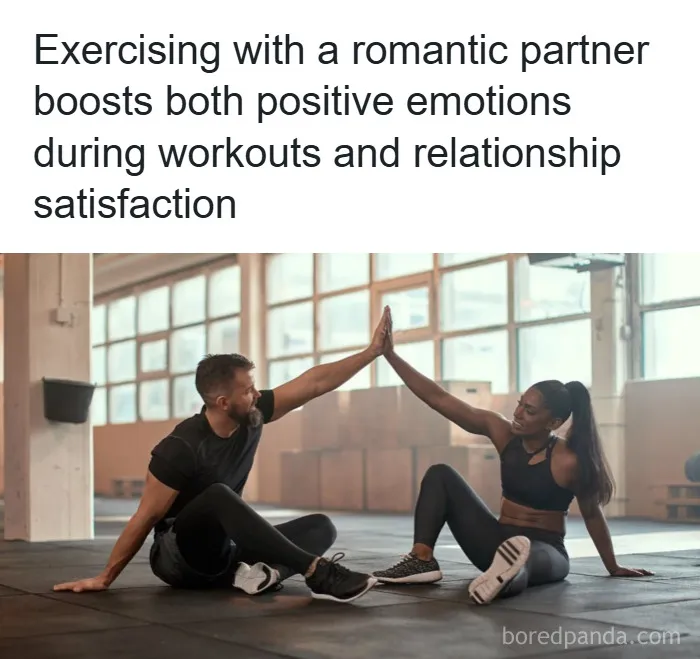 Couple exercising together indoors, sharing a high-five and enjoying positive emotions and relationship satisfaction.