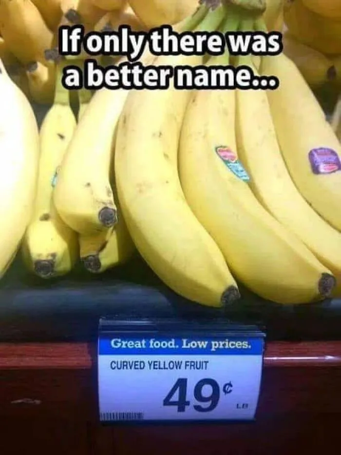 Bananas labeled as curved yellow fruit with humorous text suggesting a better name in a grocery store display, funny memes.