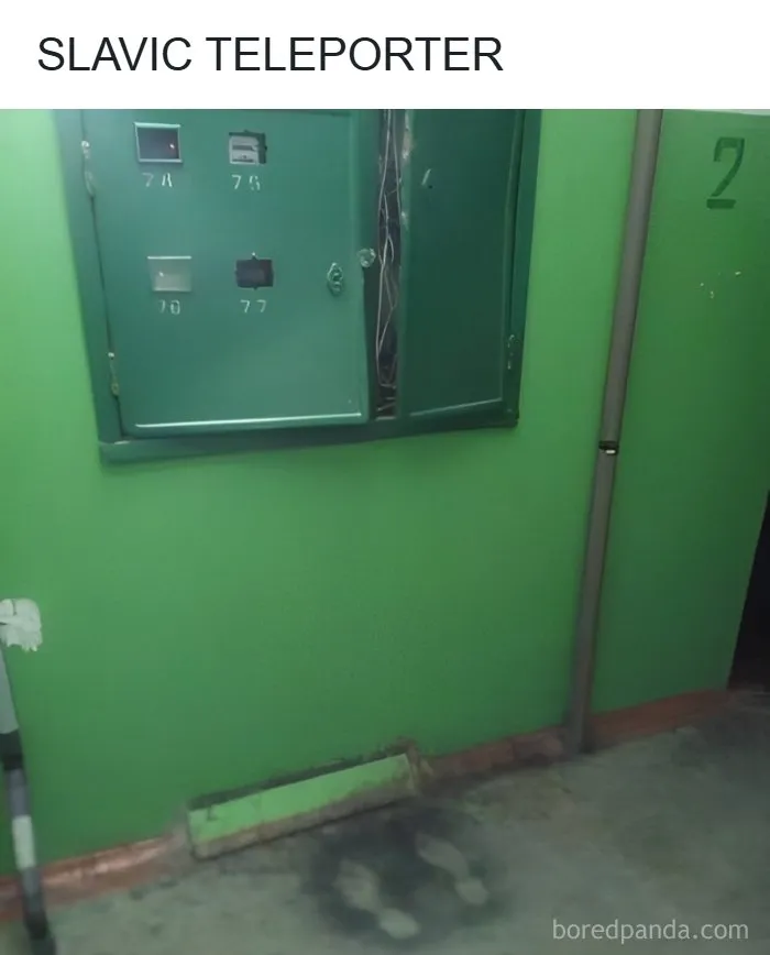 Burnt floor marks in front of an electrical panel inside an old green apartment hallway in Eastern Europe.