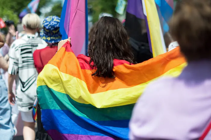 Person holding a rainbow flag at a public event symbolizing friendship struggles and final straw moments in former friendships