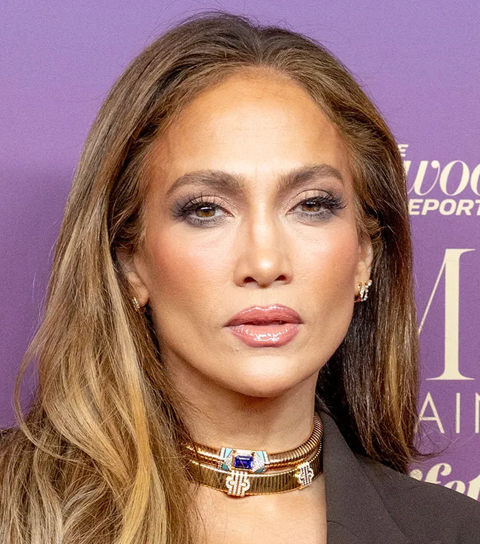Close-up of a woman with long hair and gold jewelry, representing the most disliked celebrities in 2025.