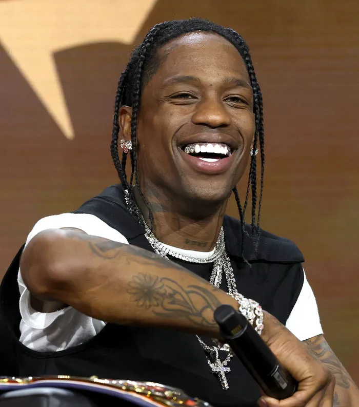 Smiling male celebrity with braided hair and tattoos, representing the most disliked celebrities of 2025 in entertainment.