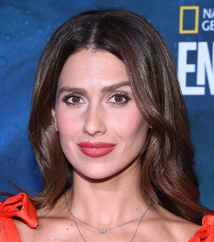 Close-up of a female celebrity with brown hair and red lipstick, featured among most disliked celebrities 2025.