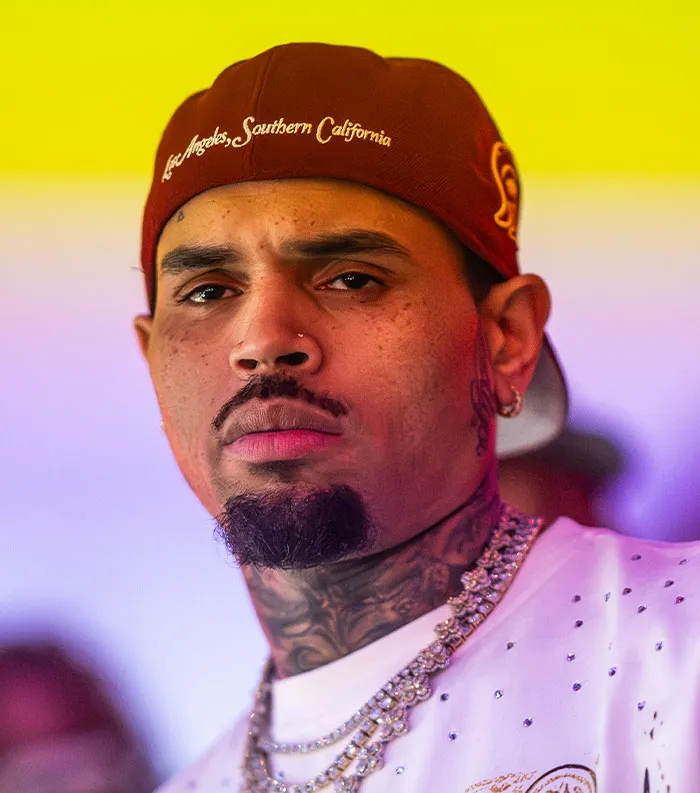 Close-up of a male celebrity wearing a red cap and chains, representing some of the most disliked celebrities of 2025.