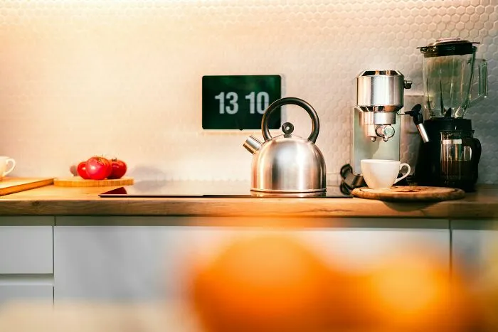 Modern kitchen countertop with kettle, coffee machine, and blender, illustrating typical household gifts people find horrible.