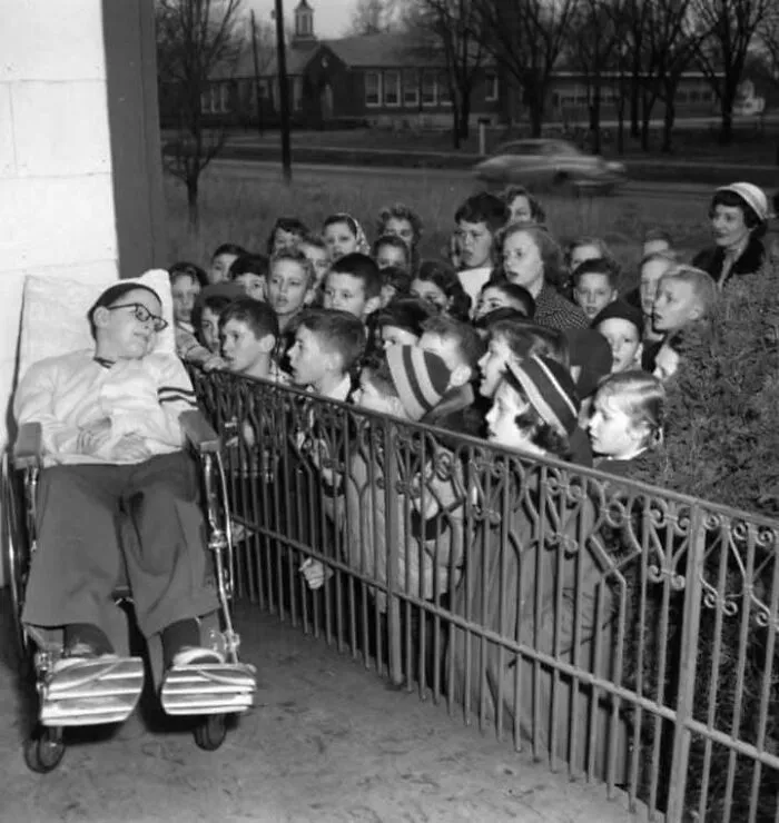 Gwinn Hinkle, víctima de la polio, en el porche de su casa mientras sus antiguos compañeros de la Sunshine School cantan villancicos. Publicado en el News & Leader, 21 de diciembre de 1952. Springfield, Misuri.