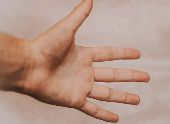 Close-up of a human hand with fingers spread, illustrating aspects of the mammalian dive reflex in the human body.