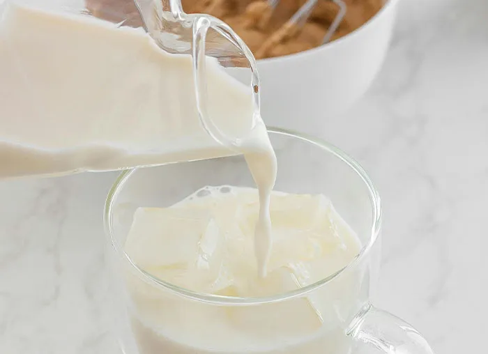 Glass mug with ice cubes being filled with milk from a clear pitcher, illustrating the mammalian dive reflex concept.