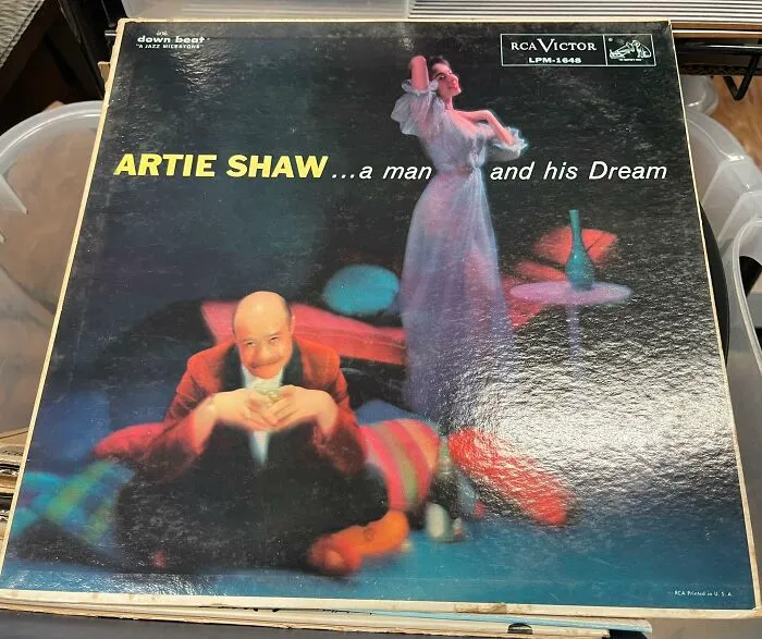 Vintage Artie Shaw album cover featuring a man and a woman in old-fashioned attire and surreal setting.