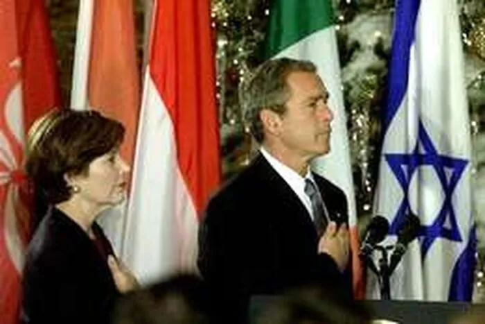 Man and woman standing with hands over hearts in front of various international flags during formal event photo illusion.