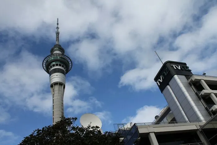 Sky Tower and nearby buildings under a partly cloudy sky, illustrating disappointing tourist attractions locals question.
