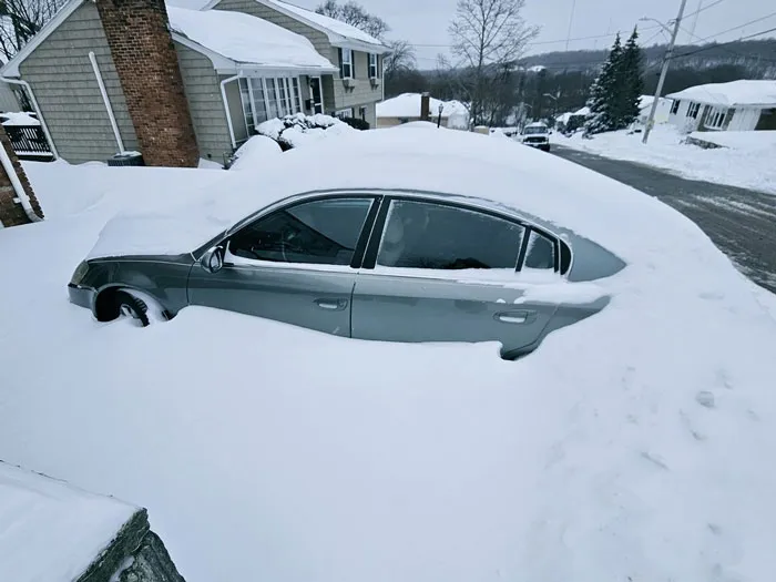 Car almost fully buried in snow after a heavy snowstorm hits a residential neighborhood in the U.S.