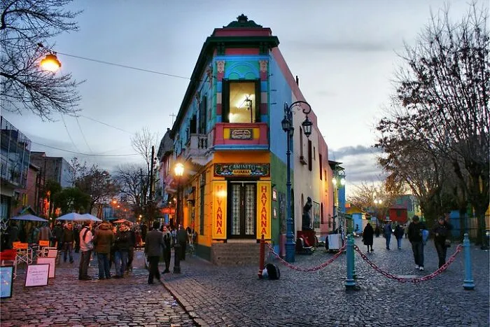 Colorful building and crowds at a popular but disappointing tourist attraction in a lively urban setting at dusk.