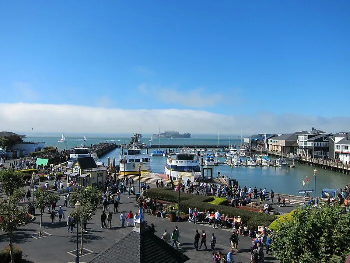 Crowded tourist harbor with boats and people on a sunny day showcasing disappointing tourist attractions in a popular destination.