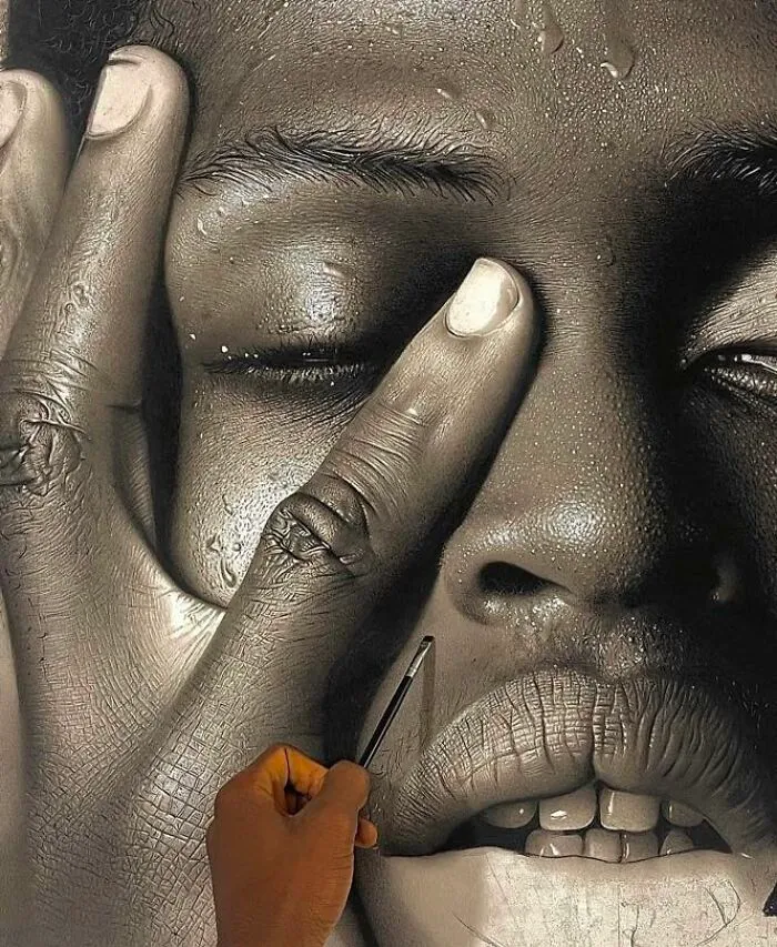 Artist creating a hyperrealistic portrait with detailed skin texture and water droplets on the face.