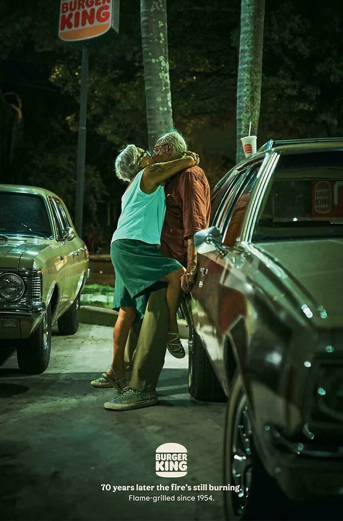 Pareja mayor besándose frente a Burger King en anuncio impreso creativo y divertido de marcas reconocidas.