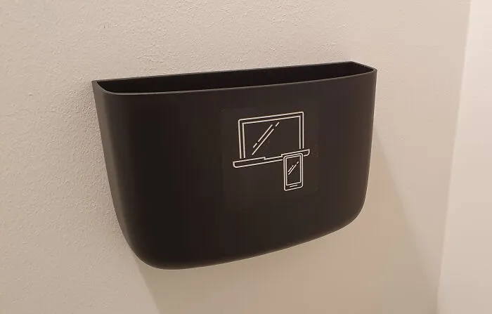 Black wall-mounted holder designed for safely storing mobile phones and small devices, showcasing impressive country innovations.
