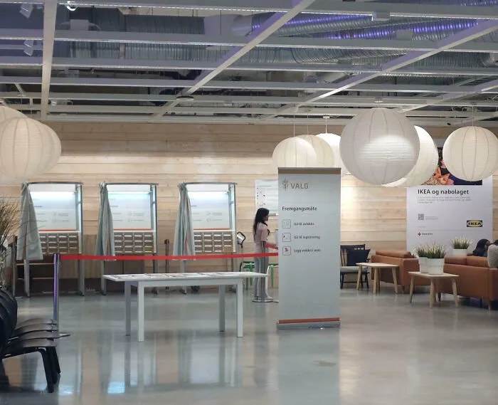 Modern voting booths in a well-lit public space showcasing impressive things countries implemented for efficient voting.