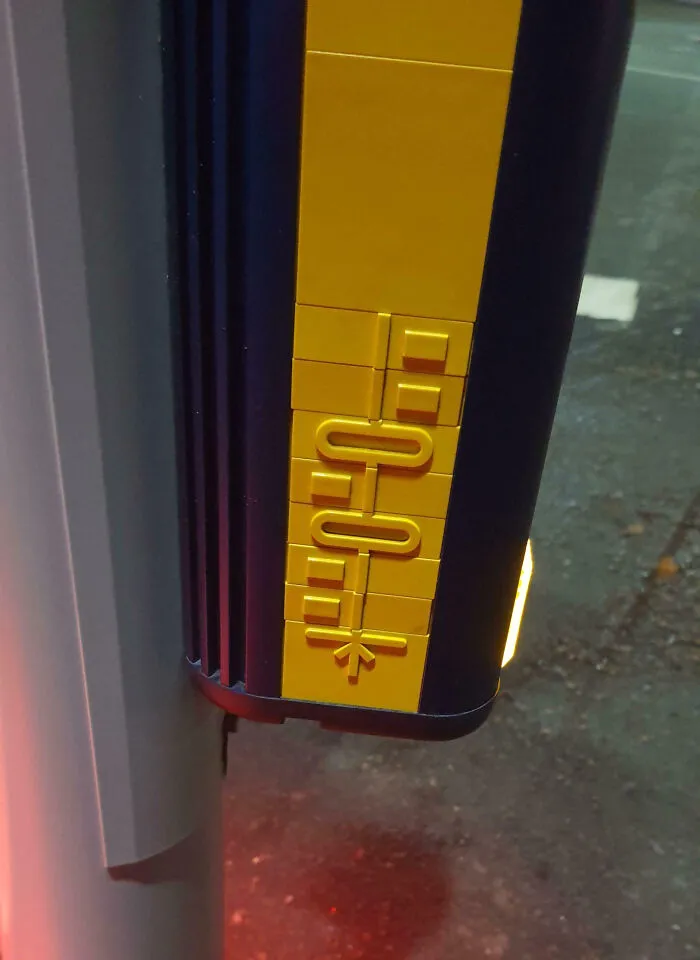 Close-up of a tactile sign made with LEGO bricks at a crosswalk, showcasing impressive things countries implemented.