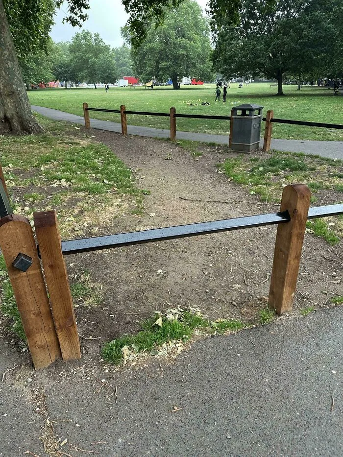 Desire paths visible where people walk through a park, bypassing the paved city sidewalk and showing urban planning vs reality.