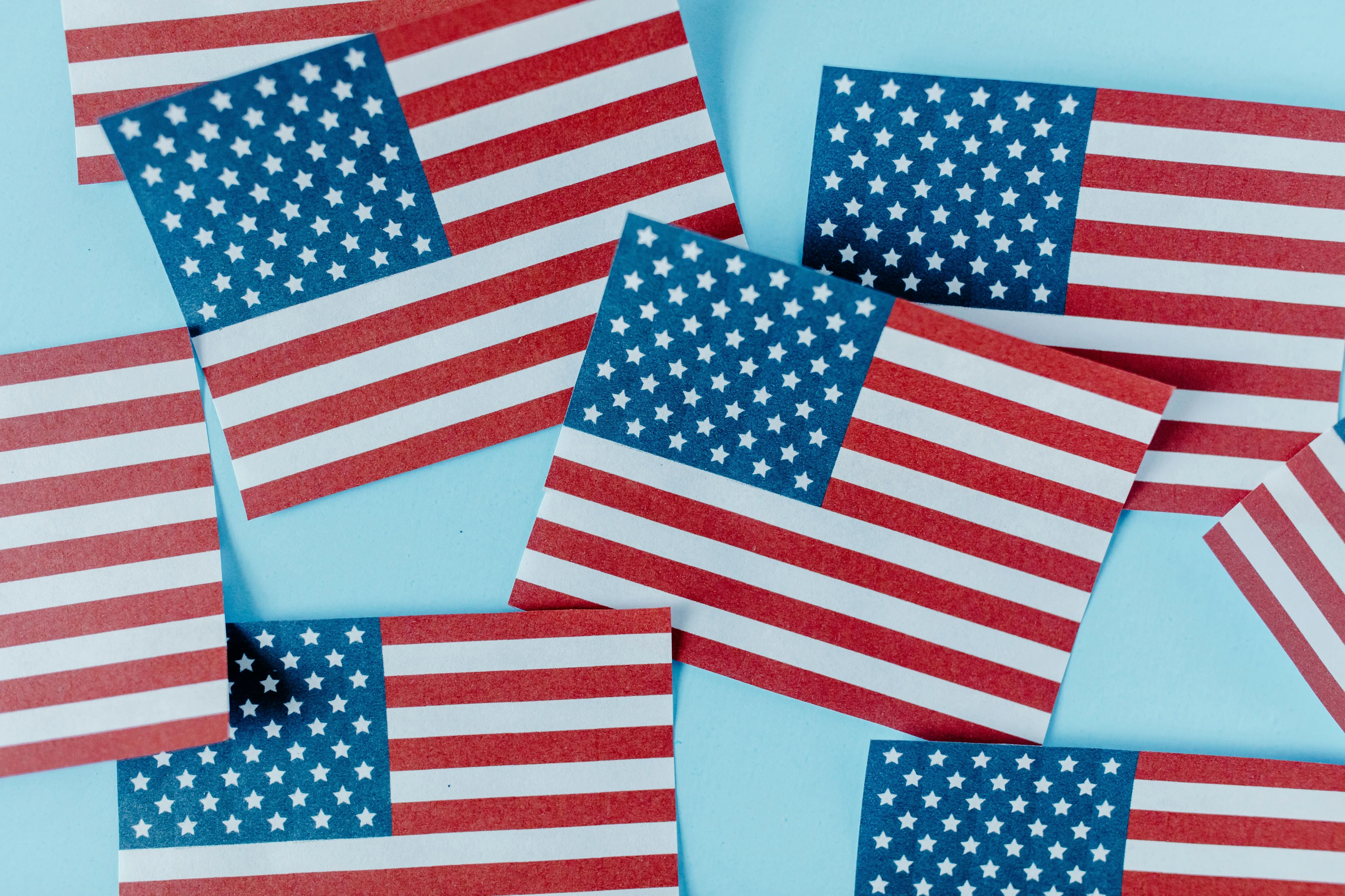 Multiple small U.S. flag cards scattered on a blue background representing historical national capitals.
