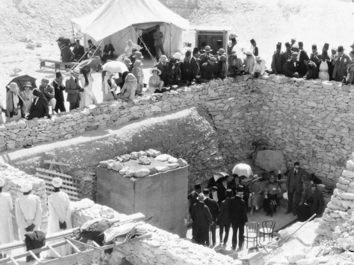 Black and white photo of people gathered at an excavation site related to unsettling history and crime cases.