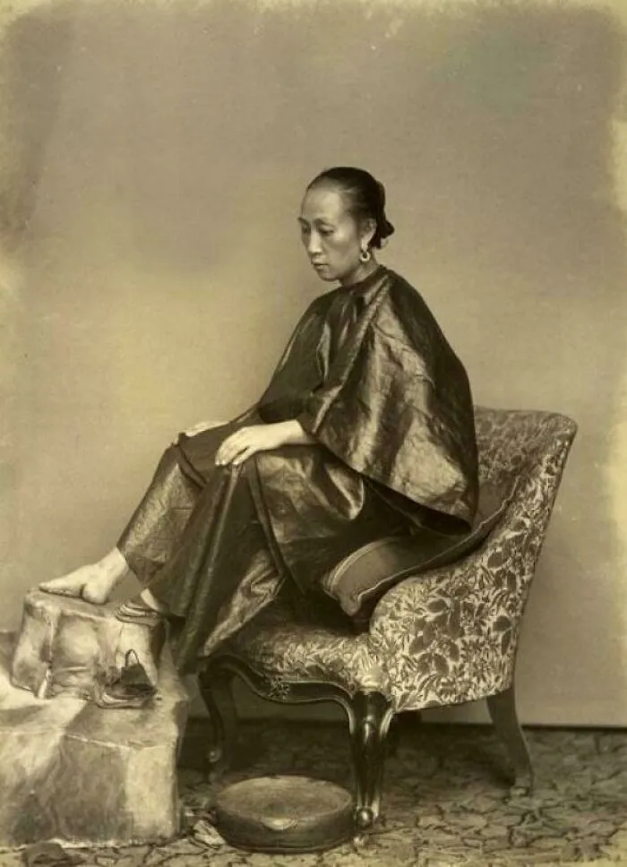 Vintage sepia photo of a woman sitting contemplatively, evoking unsettling history and crime from vanished stories.
