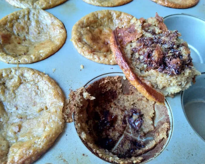 Overbaked and collapsed dessert treats stuck in a baking pan, showcasing dessert ruin fails and baking mistakes.