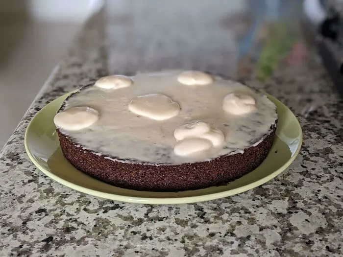Cake with uneven, poorly applied frosting on a plate, an example of how people managed to ruin dessert unexpectedly