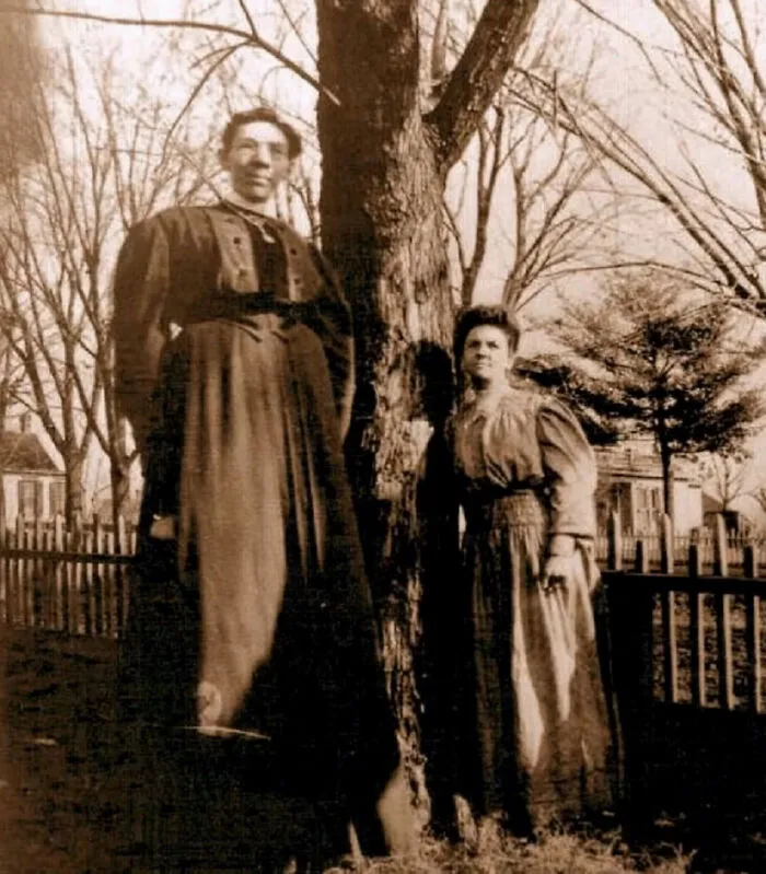 Ella Ewing Posing With A Regular Size Woman By The Tree, Circa 1890s. She Was 7ft 4.5 (Billed As 8ft4 By The Circus)