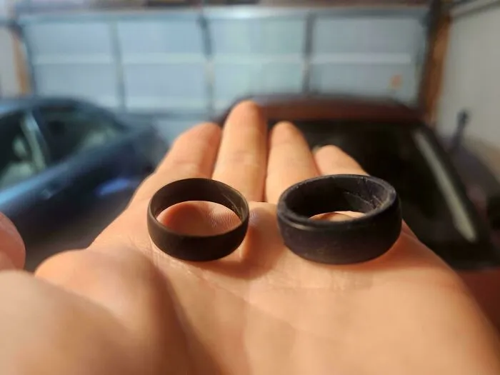 Two black rings held on a hand showing worn down edges and surface from everyday use over time