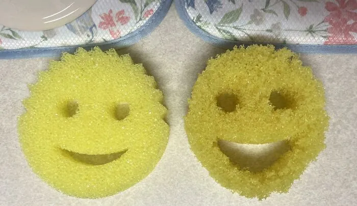 Two yellow dish sponges shaped like smiley faces showing wear and tear on a kitchen countertop, everyday objects worn down.