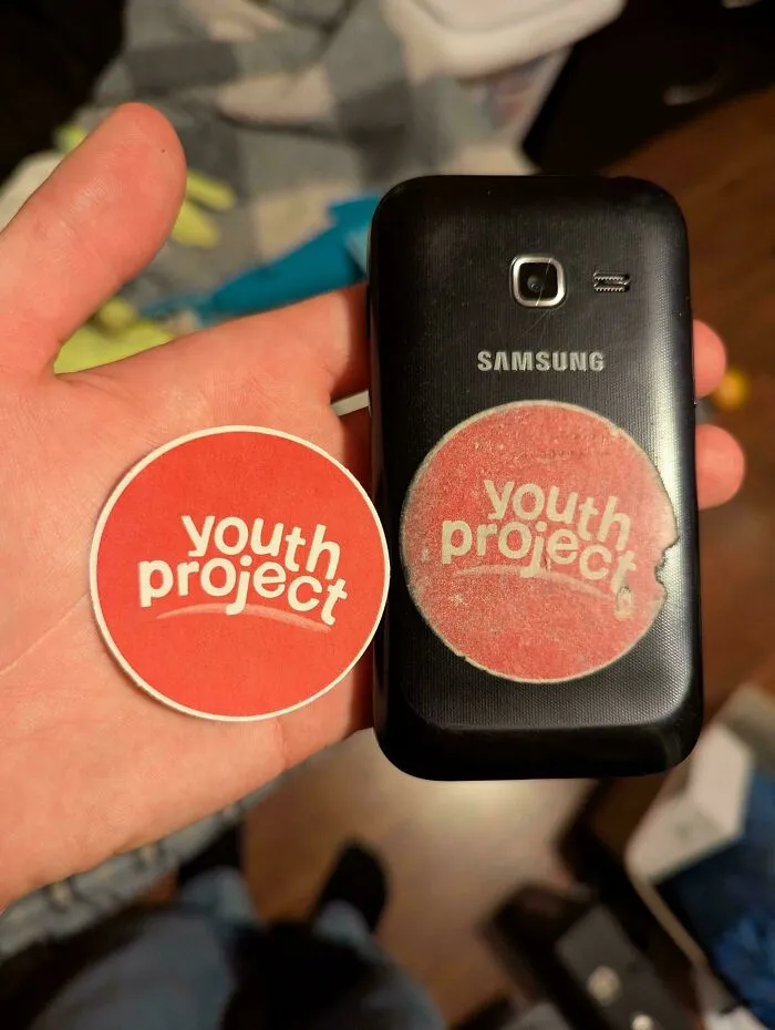 Worn down sticker on the back of a Samsung phone showing effects of everyday object wear in unexpected ways.