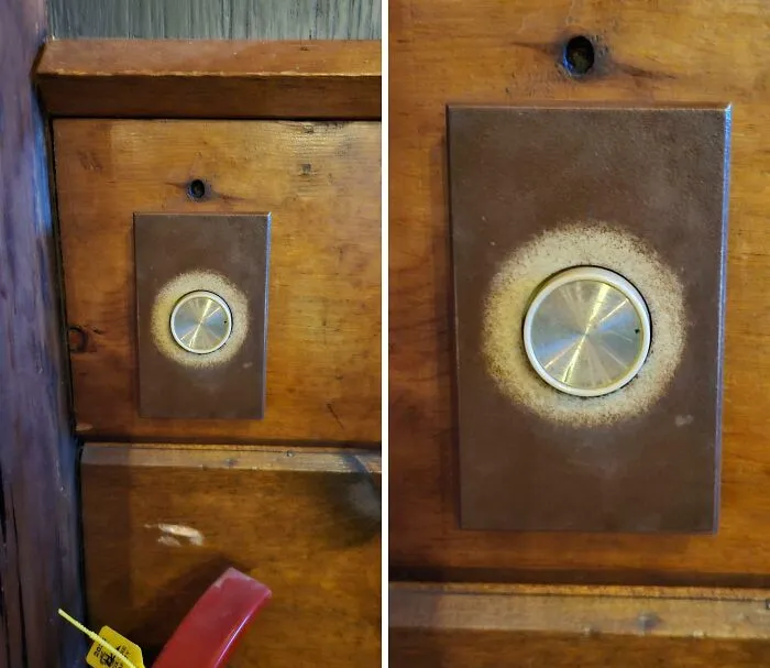 Close-up of a worn-down metal knob on aged wooden panel showing unexpected wear on everyday objects.
