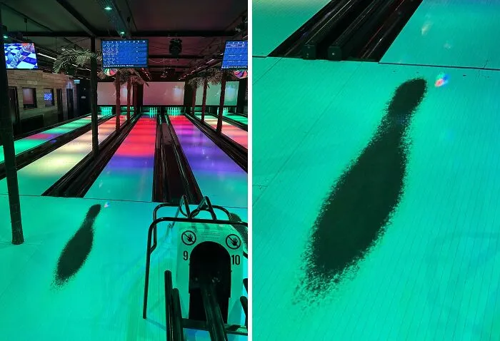 Worn down bowling lane showing a polished, darkened area from repeated use and ball impact over time.