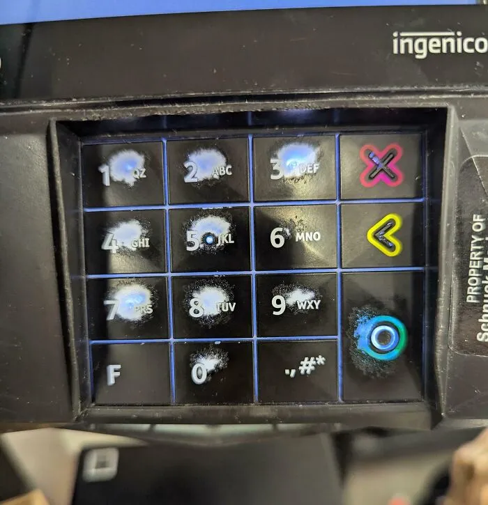 Worn down keypad buttons on an Ingenico payment terminal showing signs of heavy everyday use.