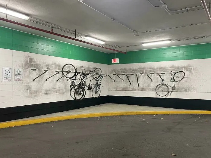 Bicycle parking area showing worn down wall marks and residue from everyday objects in an unexpected way.