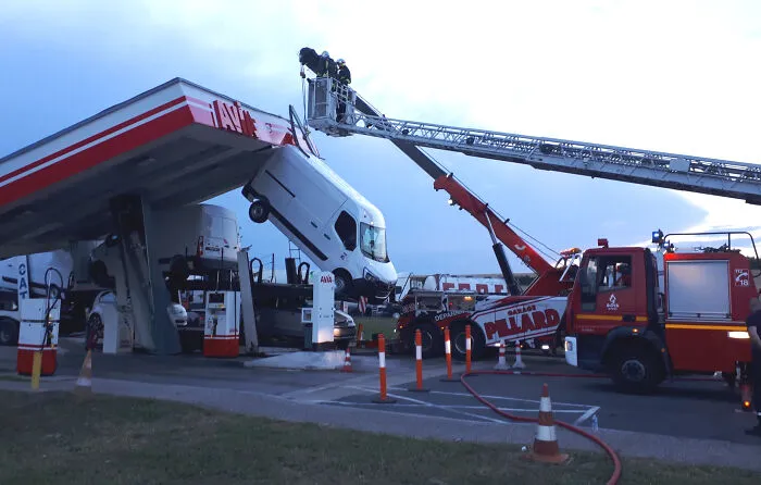 Delicate Evening Operation On The A4 Highway At The Valmy Rest Area. A Heavy Truck Transporting Utility Vehicles Crashes Under The Canopy Of A Gas Station