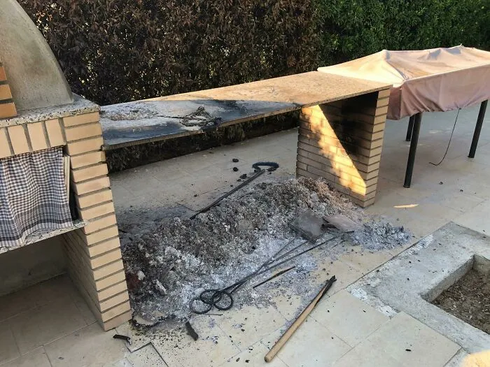 Montón de cenizas y herramientas quemadas en área exterior, mostrando errores costosos que podrían hacerte decir ouch.